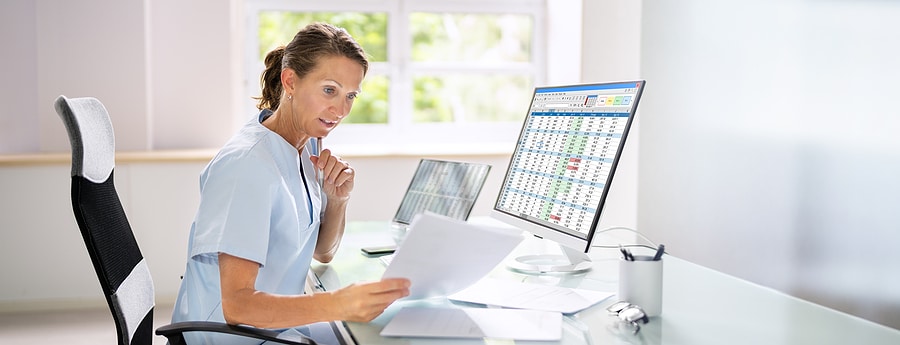 Healthcare analyst intently reviewing profit reports for a client's medical practice.